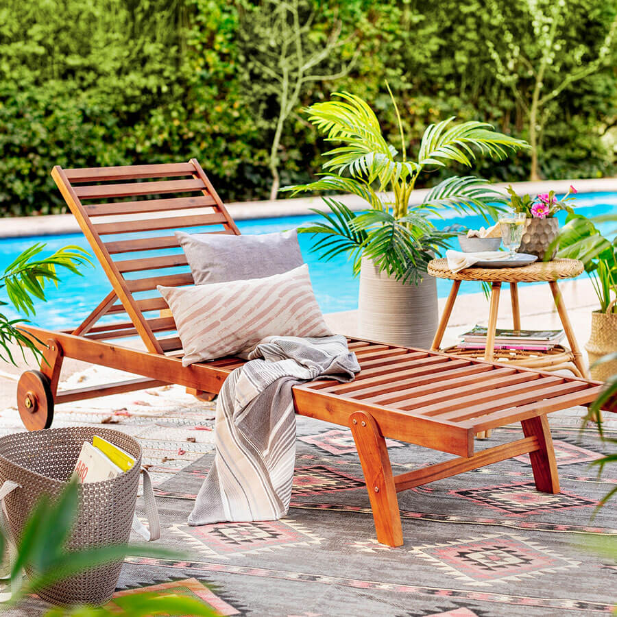 Reposera de madera al borde de la piscina con mesita se bambu y plantas muebles terraza - reposera de bambú