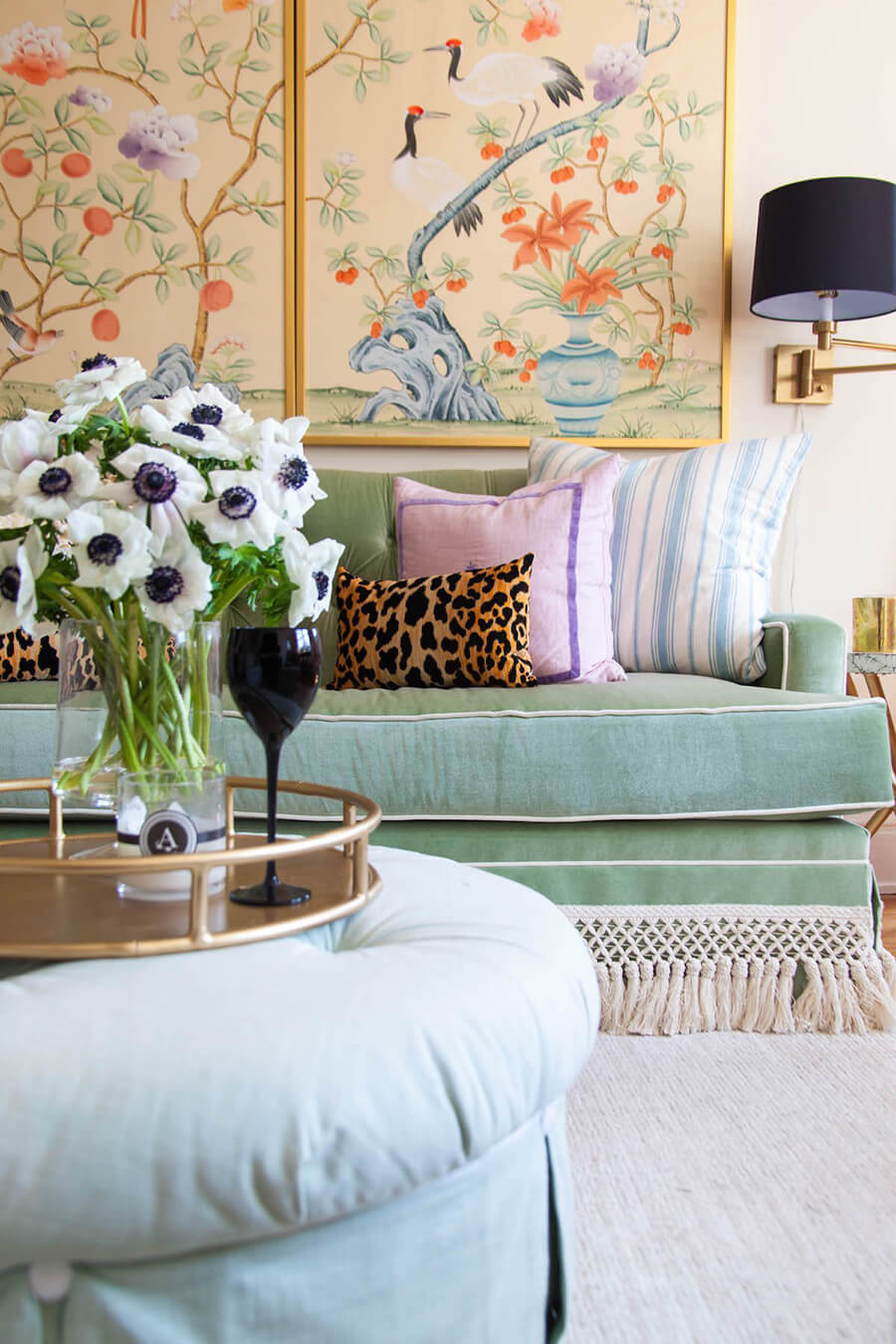 decoración grandmillenial con toque oriental decoración ecléctica de living con un tríptico oriental de fondo y cojines de distintos estilos sobre sofá verde menta