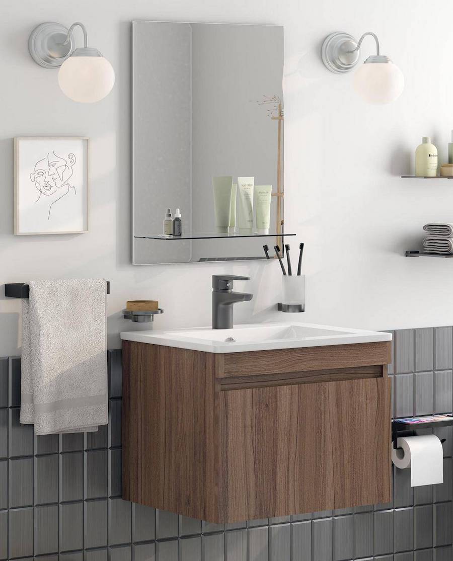 Baño con un mueble vanitorio de madera y sobre él, un espejo sin marco rectangular.
