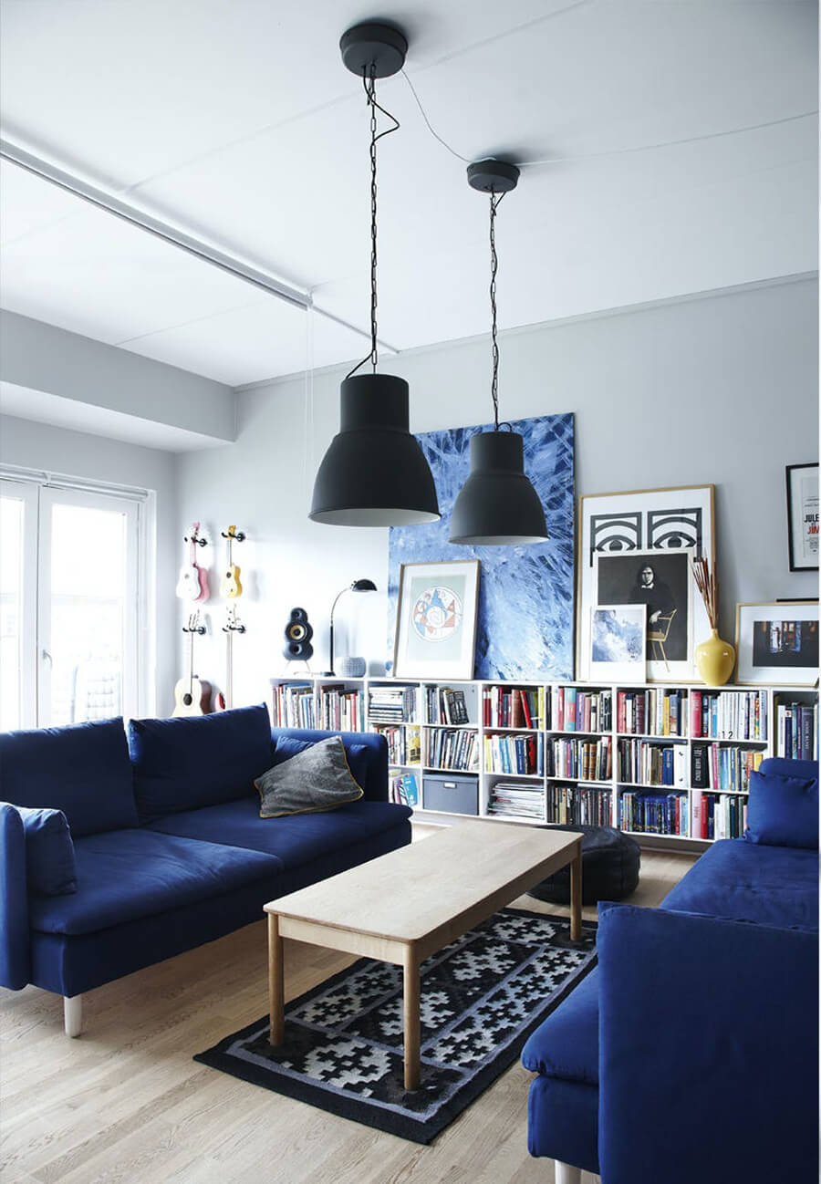 Dos sofás enfrentados Un living con un librero grande y 2 sofás de color azul enfrentados para mejorar la decoración de living