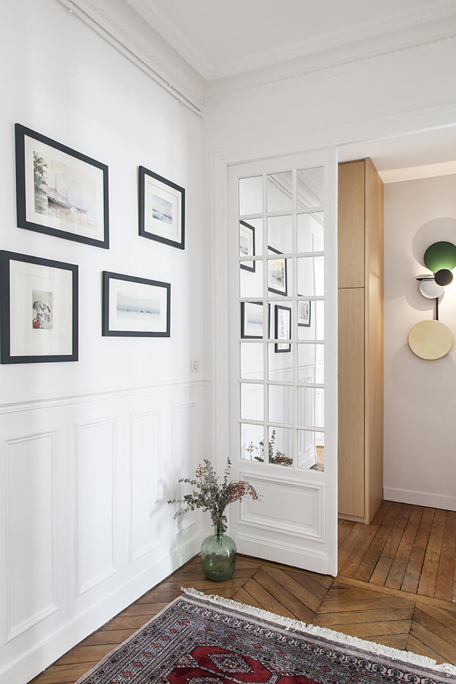 Recibidor con pared blanca y cuadros decorativos con marco negro