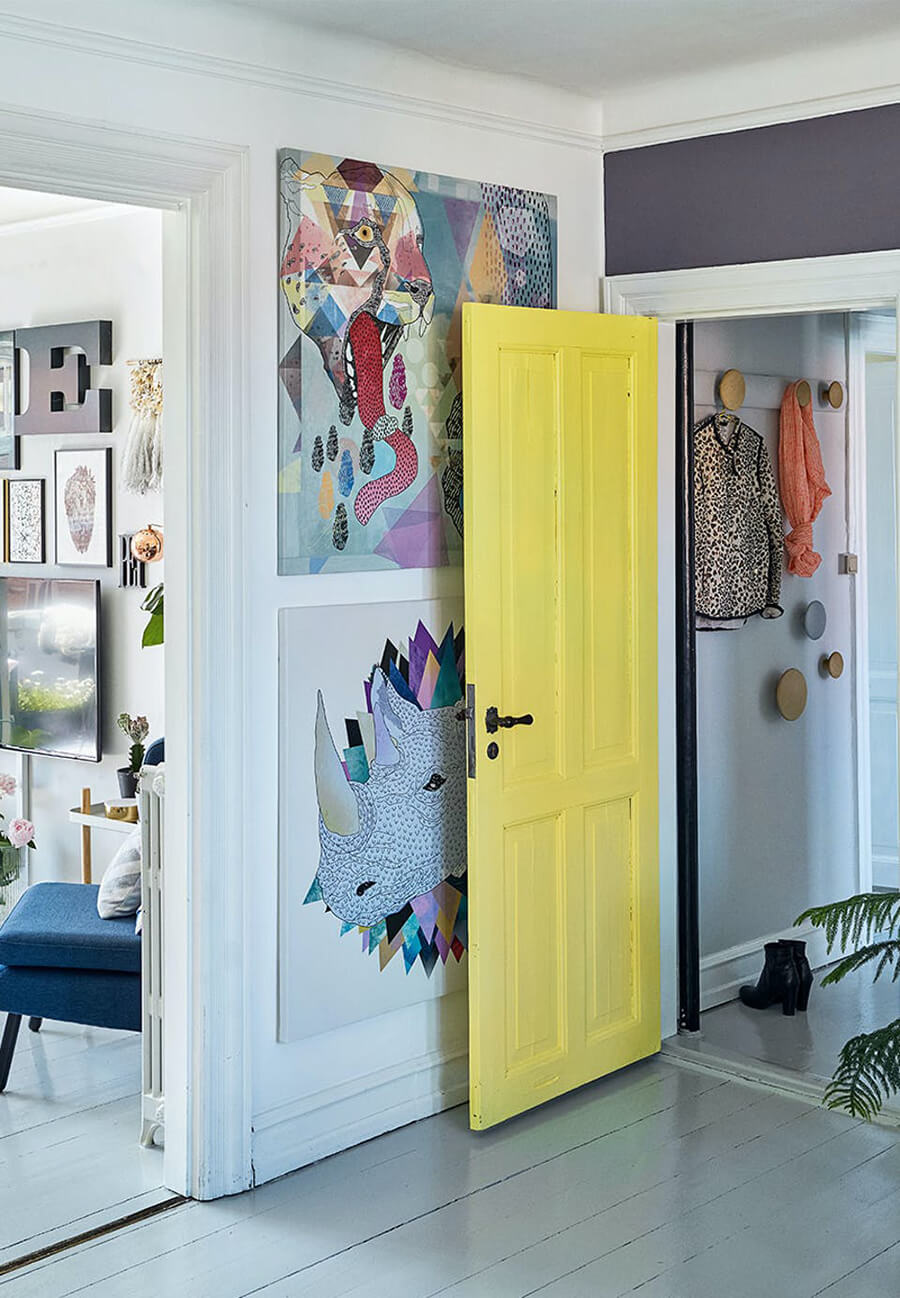 la entrada a un espacio de la casa con muchas decoraciones y una puerta pintada de color amarillo iluminating.