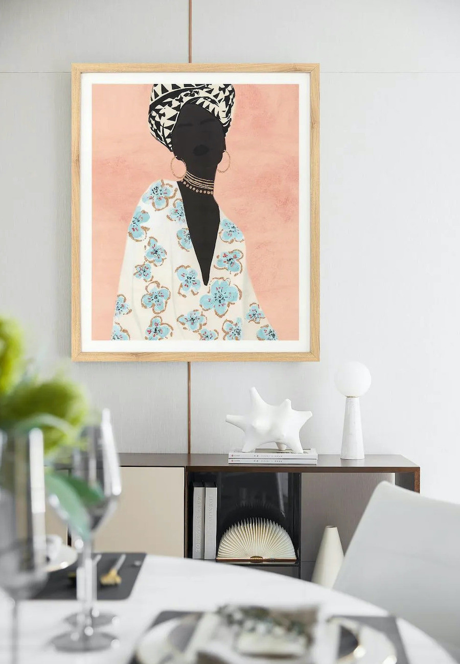 Comedor con un buffet de madera oscura y sobre él, un cuadro de una mujer con colores pastel y marco de madera clara.