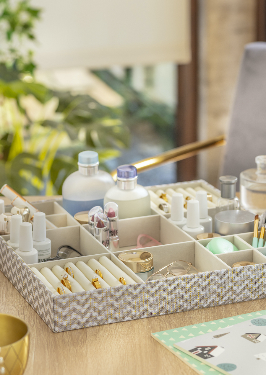 Detalle de un organizador de tela con joyas y cremas en sus diferentes compartimientos.