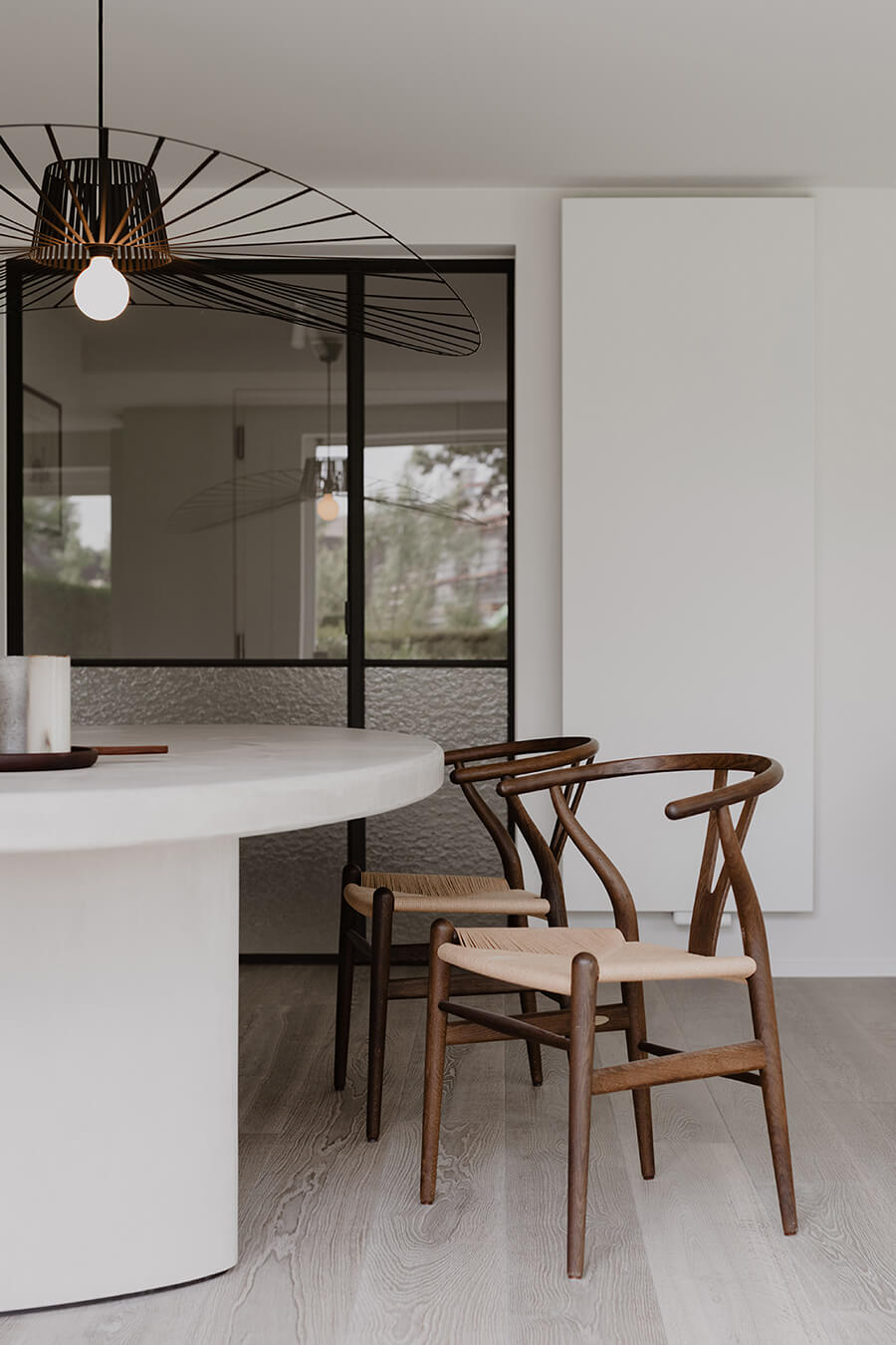 Silla Wishbone Sillas de diseño, modelo Wishbone, frente a una mesa blanca