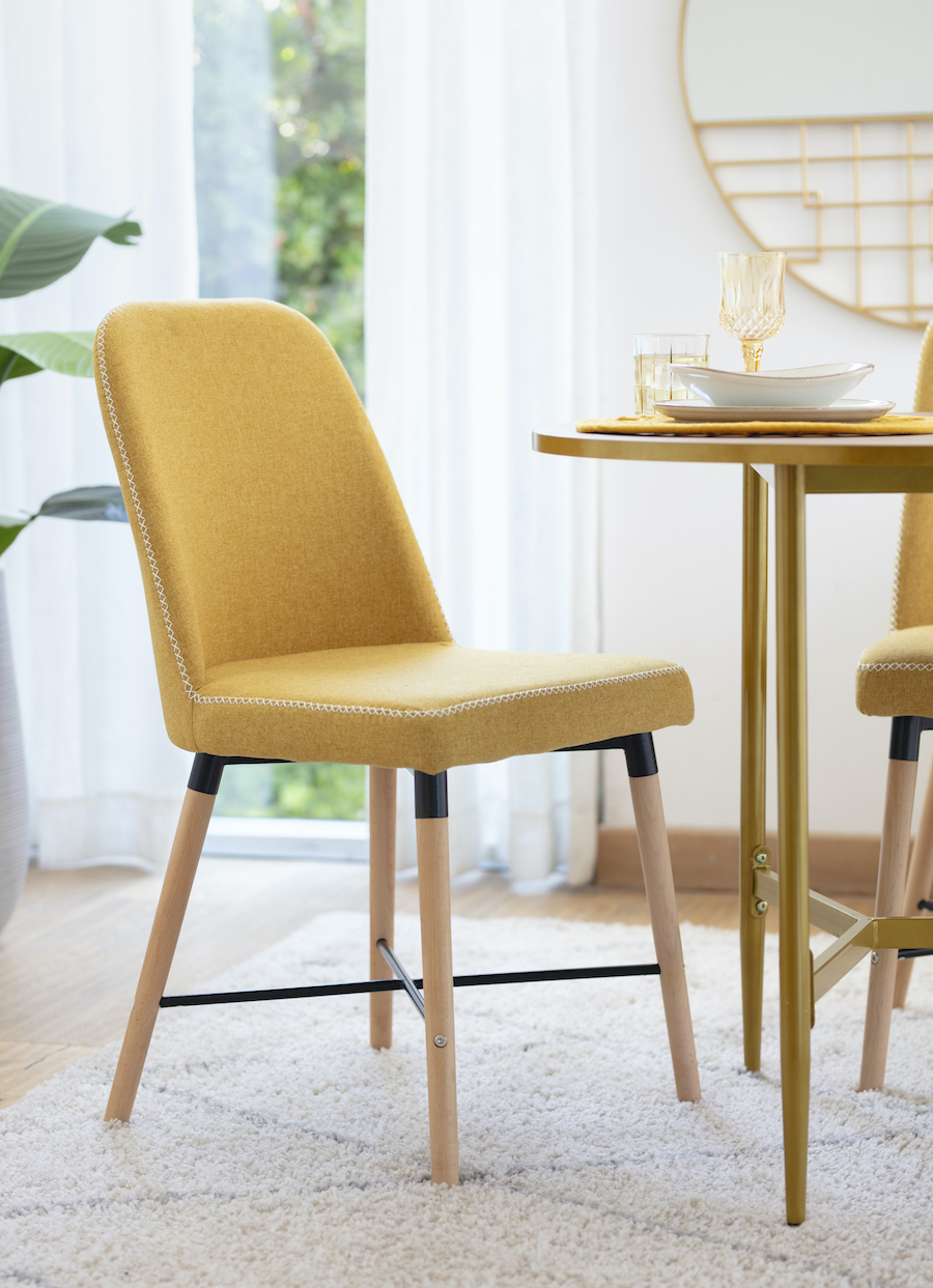 Silla de comedor color mostaza con patas de madera.