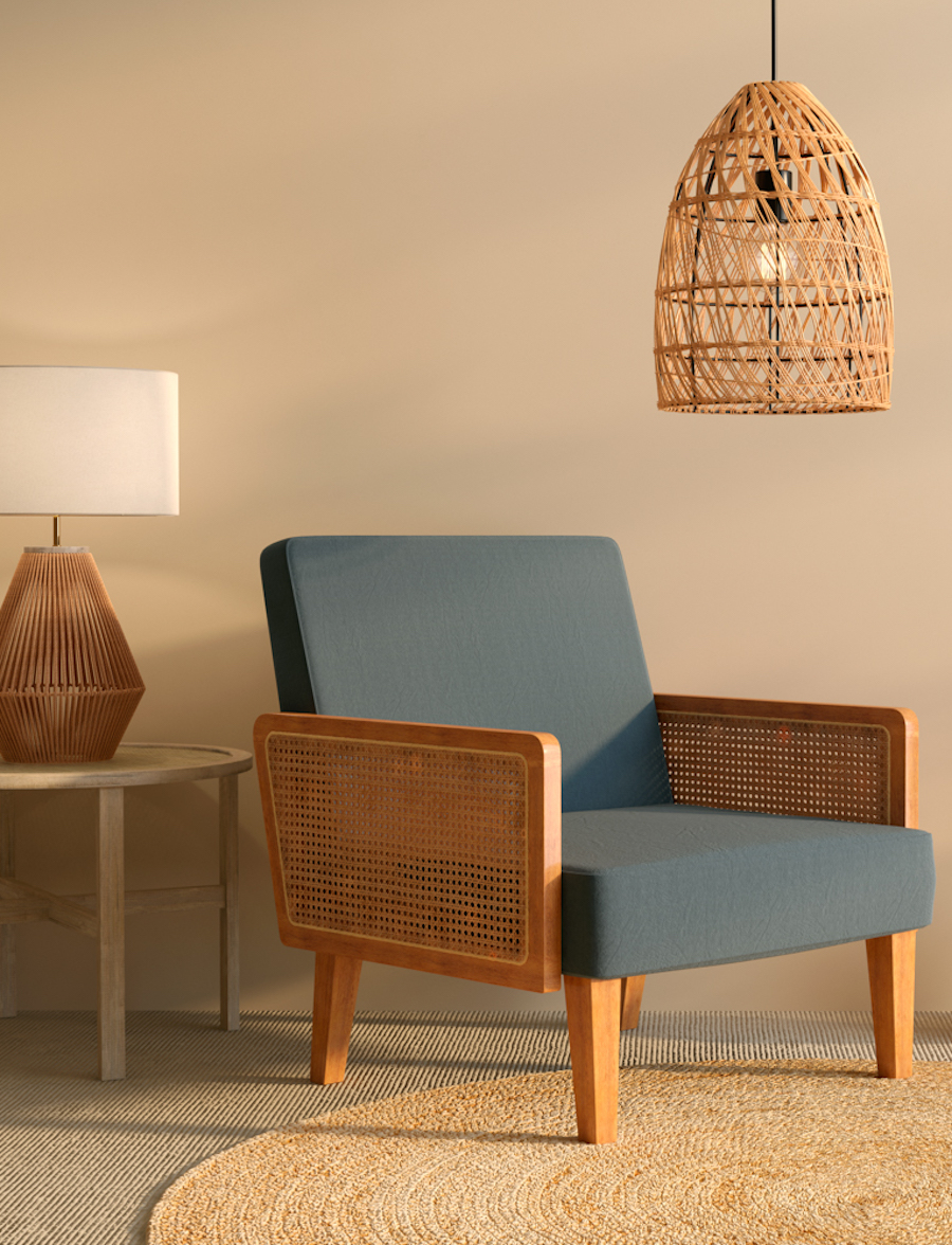 Sala de estar con una poltrona azul con detalles de ratán junto a una mesa lateral con una lámpara de mesa sobre ella. Del techo cuelga una lámpara de mimbre.