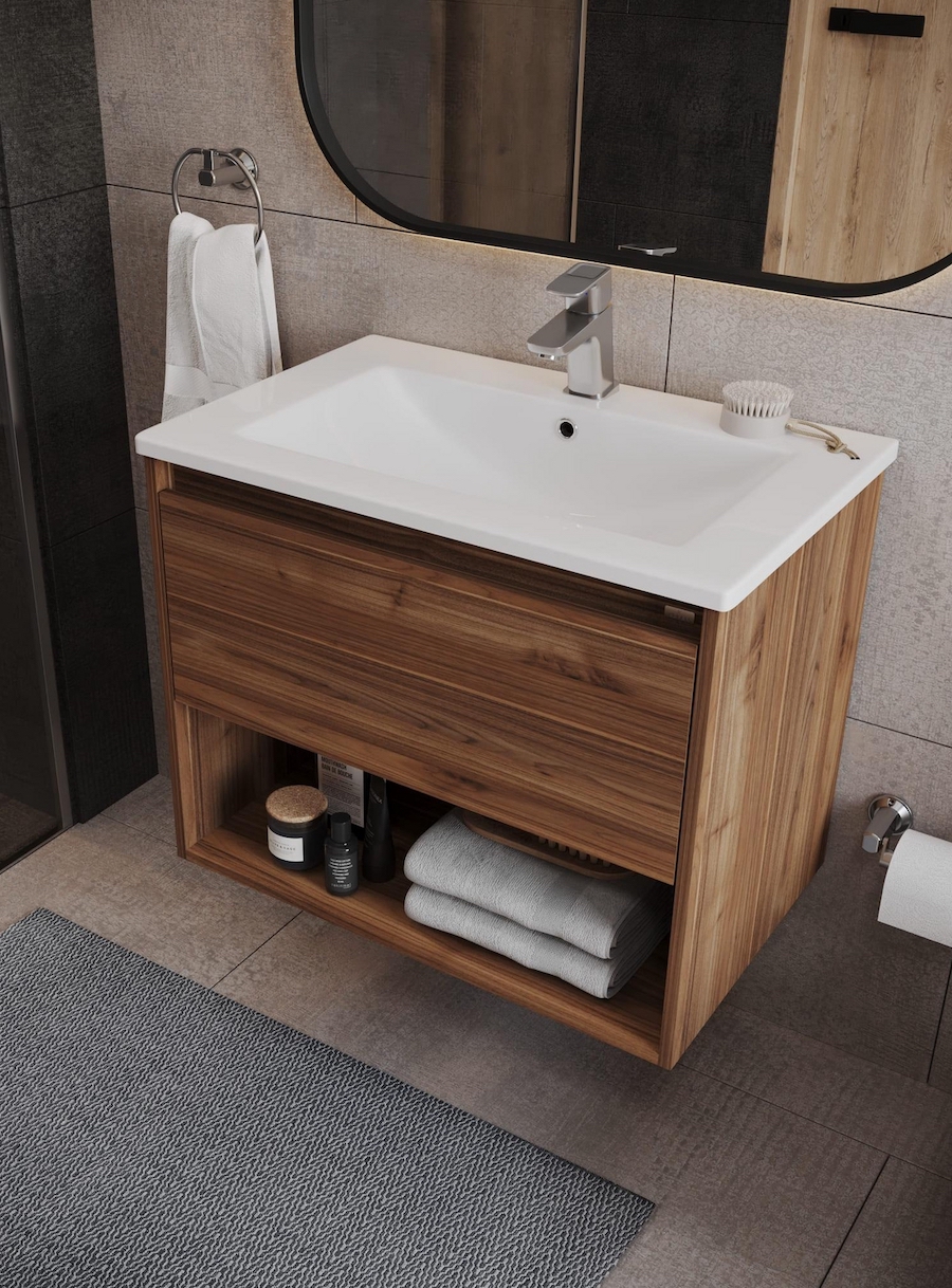 Baño rústico moderno con vanitorio de madera con espacio de almacenamiento. Toallas y textiles blancos. En el piso hay una alfombra pequeña de tonos azules.