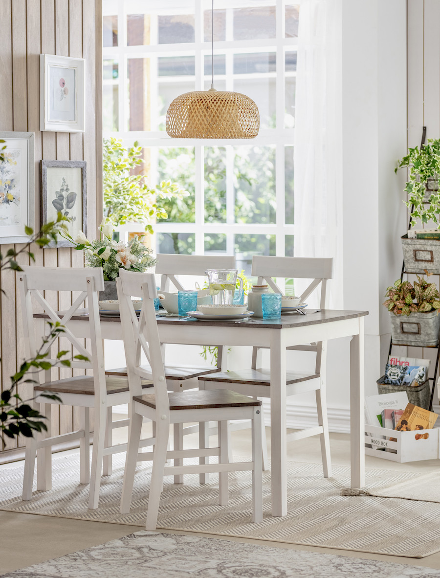 Comedor decorado con estilo natural, lámpara de fibras naturales, sillas blancas y detalles florales, ideal para ambientes cálidos, nórdicos y acogedores.
