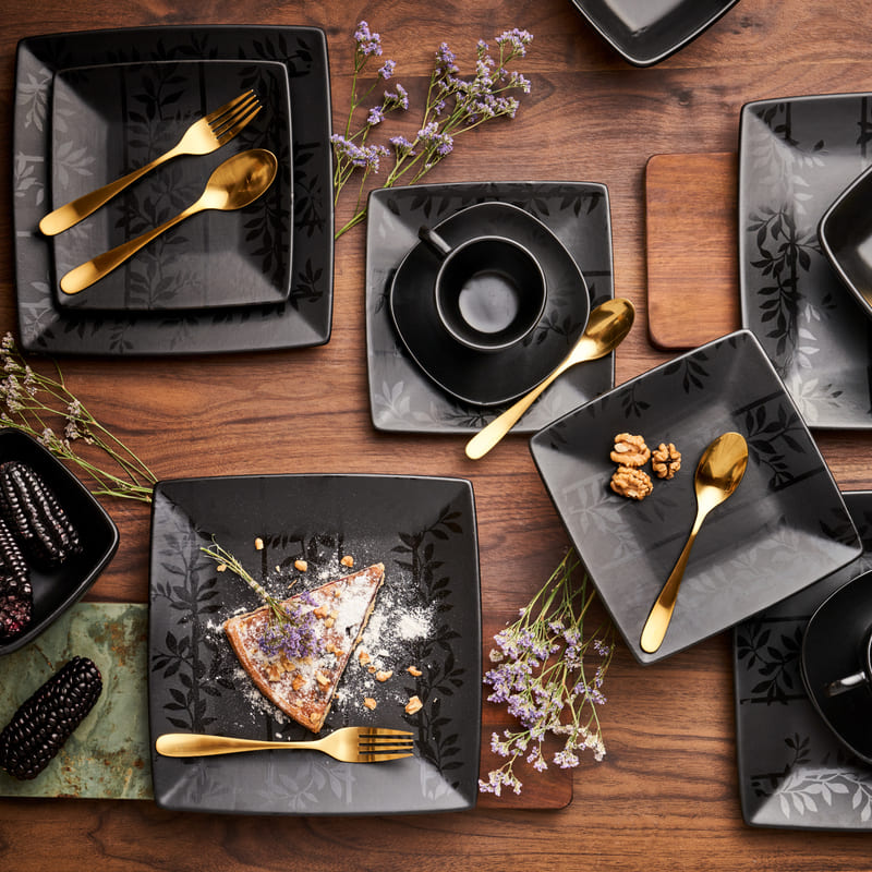 Juego de mesa negros con menaje dorado.