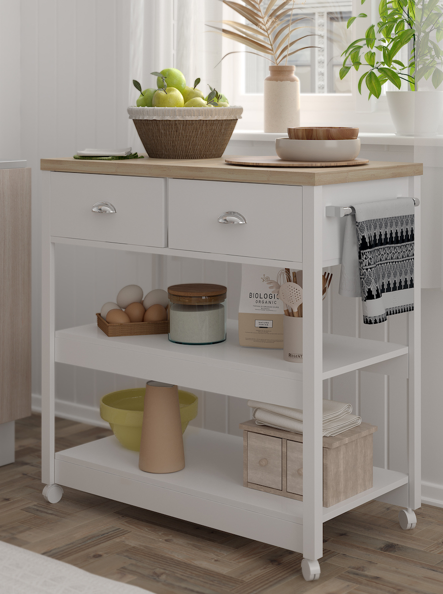 Isla de cocina de estilo nórdico, de estructura blanca y superficie de madera clara. Sobre ella hay una frutera con manzanas verdes y bowls de colores neutros. Debajo de sus cajones hay frascos, cajas y utensilios de cocina.