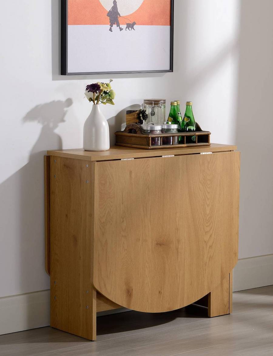 Arrimo de madera que se transforma en mesa. Sobre él hay un florero blanco y una bandeja con diferentes elementos para la hora del té.