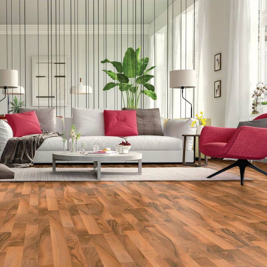 Living de estilo moderno con piso flotante de madera café rojiza. Sillón blanco con cojines grises y rojos. Mesa de centro redonda, color gris. Sofá de estilo sónico, de tapiz rojo, alfombra gris. Ambiente separado del comedor con unas cuerdas negras