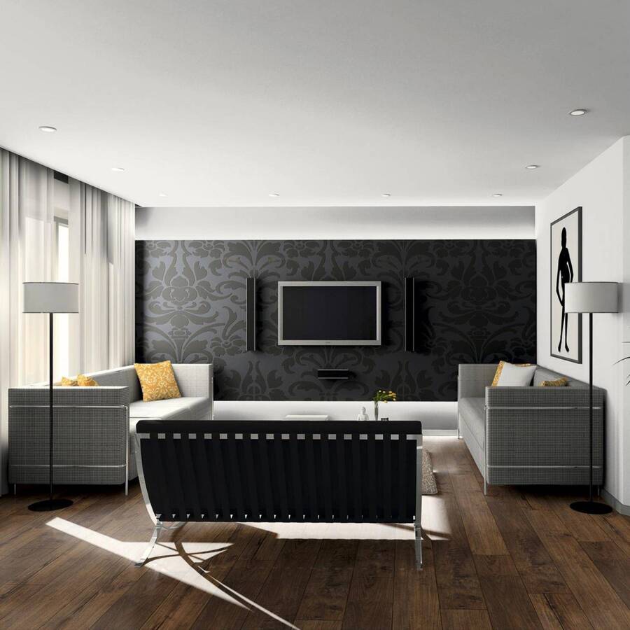 Living moderno con muros blancos y un muro con papel mural negro. Piso flotante de madera café escuro. Tres sillones, dos de tela color gris y uno de cuero negro y patas metálicas. Lámpara de pie con pantalla blanca y gran cuadro en el muro