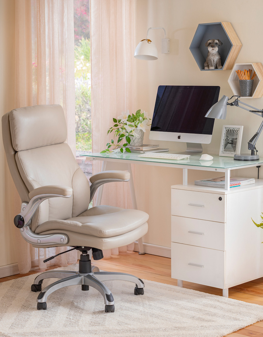 Escritorio moderno con silla ergonómica color beige. Escritorio blanco con cajones y base de vidrio.