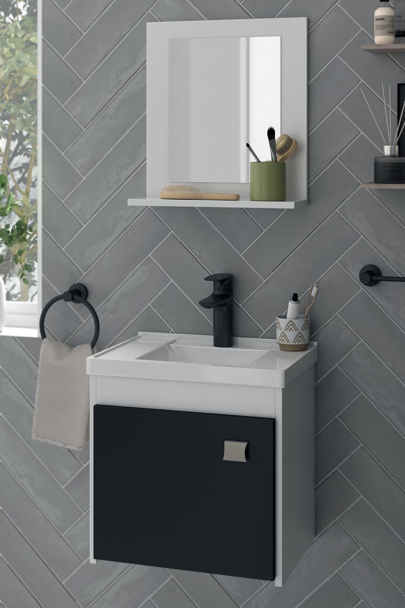 Baño estilo industrial con paredes de cerámica color gris oscuro. Los muebles son blancos con detalles negros y los accesorios, como el toallero y monomando, son también negros.