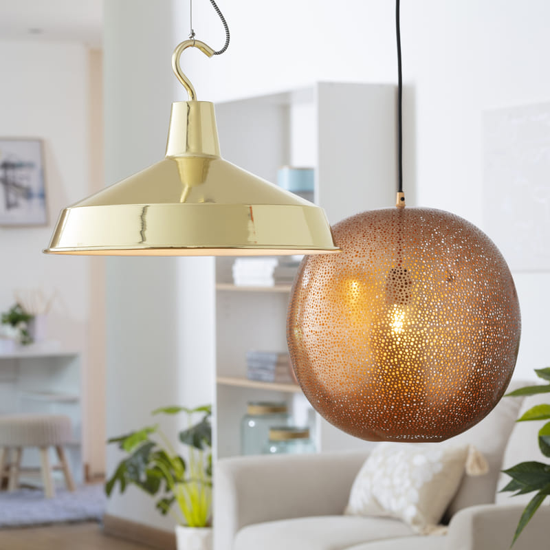 Dos lámparas colgantes, una con pantalla dorada y otra de vidrio color caramelo.