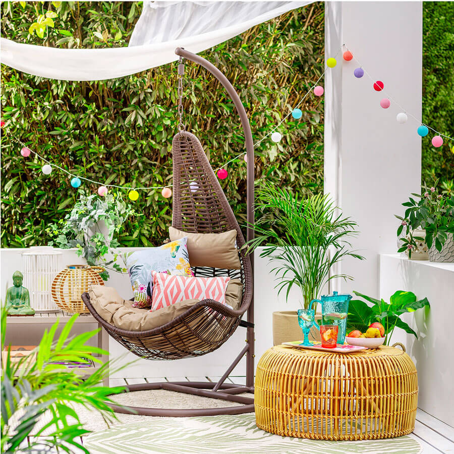 Silla colgante de rattan en terraza Silla colgante de rattan en terraza