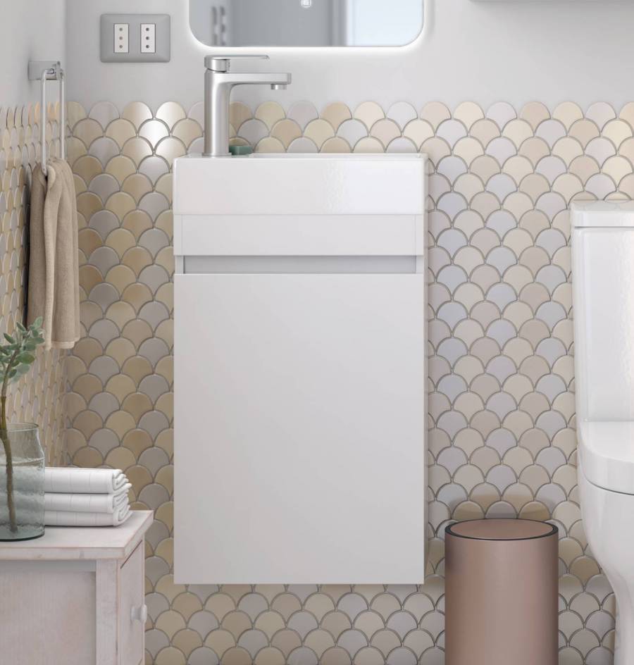 Baño con cerámica tipo mosaico en tonos dorados y crema, WC blanco y mueble vanitorio rectangular con grifería plateada.